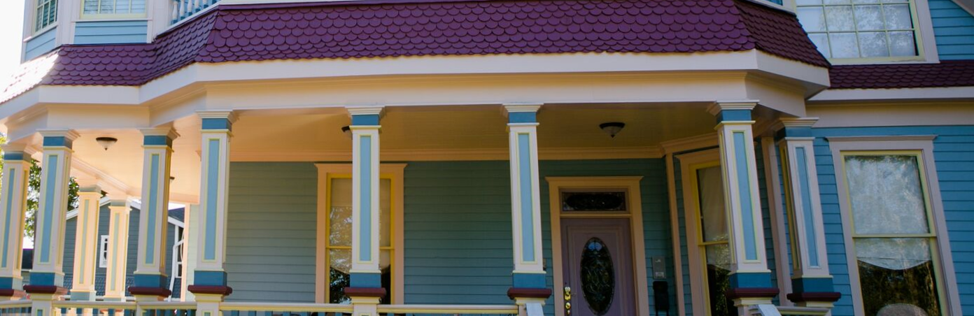 A blue and white house with a large porch and columns.